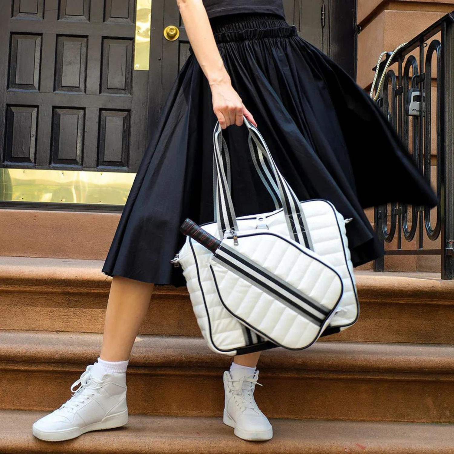 NILK Praline white pickleball bag with paddle – quilted tote carried by player on-the-go.